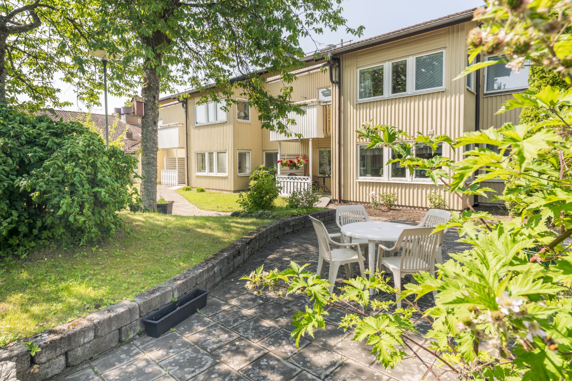Stensatt sittplats på gården framför husen