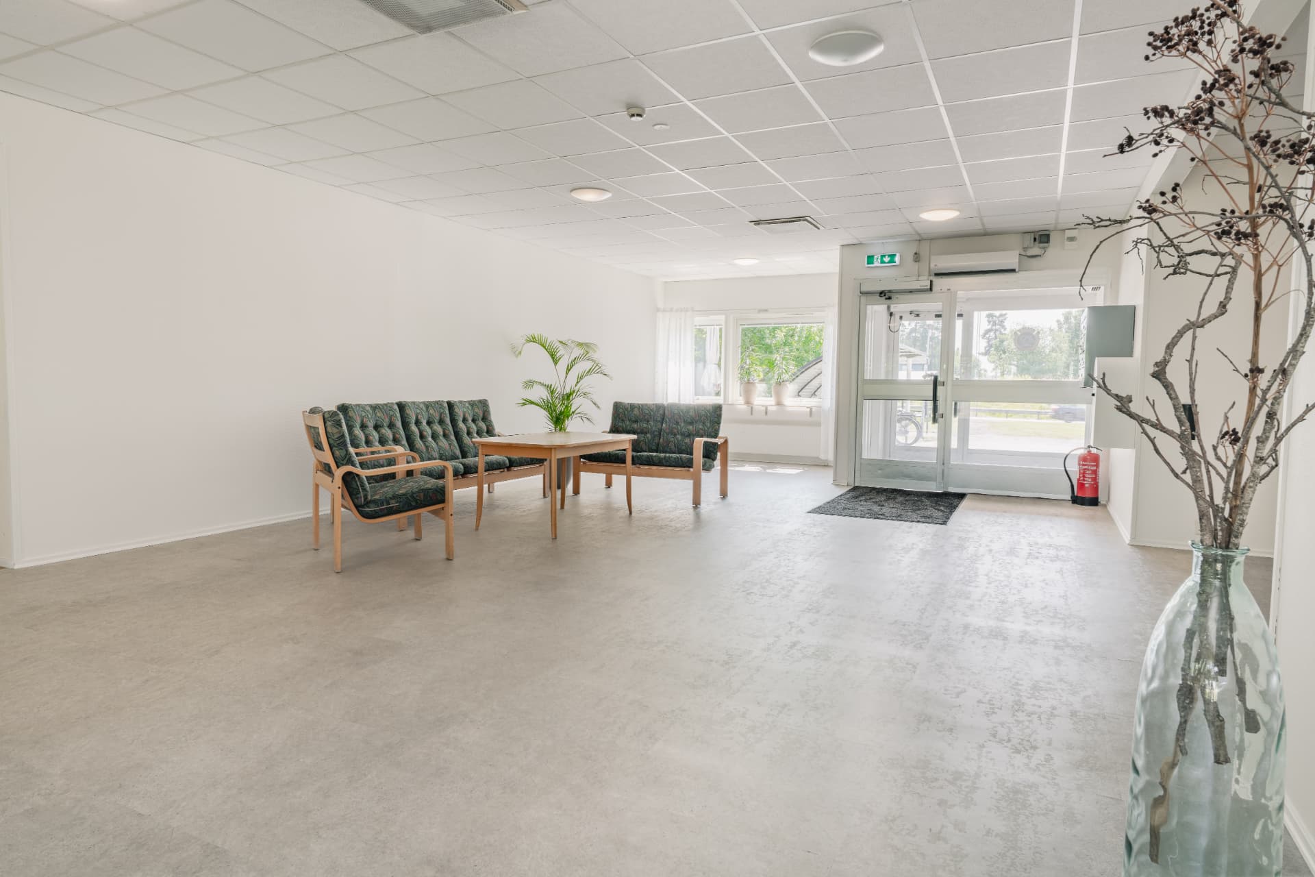 Entréhall i Kvartershuset med sittgrupp och automatiska glasdörrar